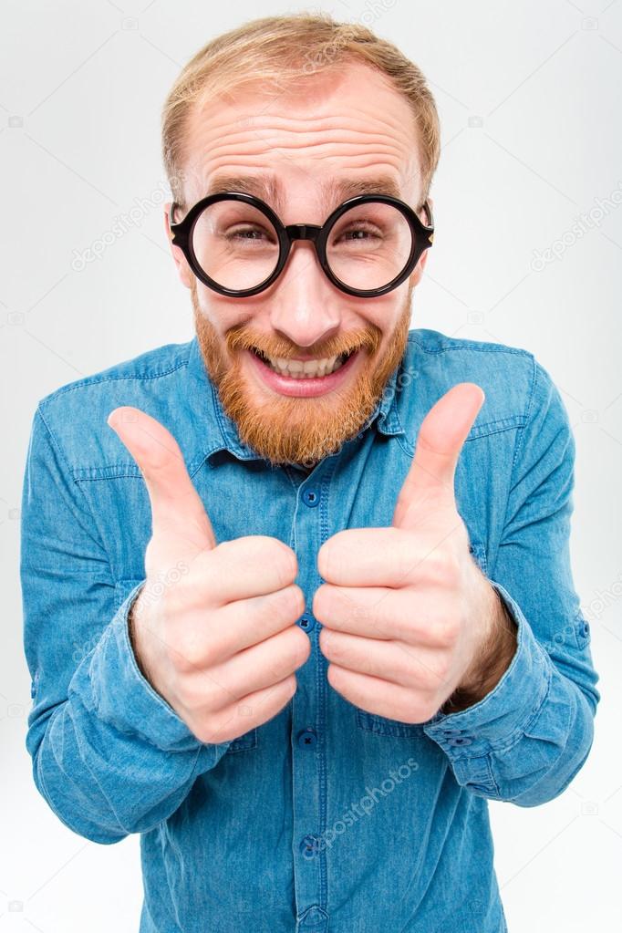 Funny cheerful bearded man in round glasses showing thumbs up