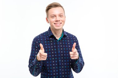 Joyful charming young male pointing on you with both hands