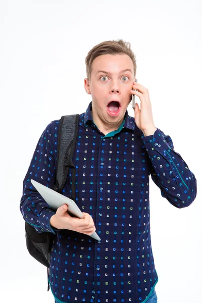 Amazed male student talking on the phone — Stockfoto