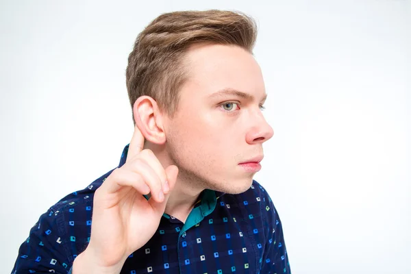 Curious blond young man trying to hear rumors — Stockfoto