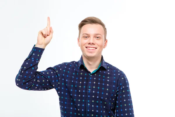 Cheerful attractive young blond man in checkered shirt pointing up — Stockfoto