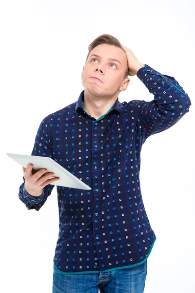 Nachdenklicher Mann hält Tablet-Computer in der Hand und blickt auf — Stockfoto