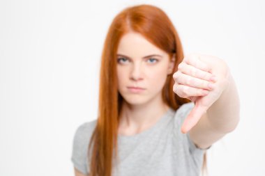 Angry frustrated young redhear female showing thumbs down  