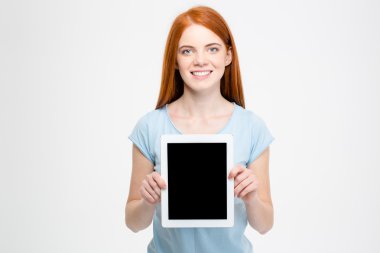 Redhead woman showing blank tablet computer screen