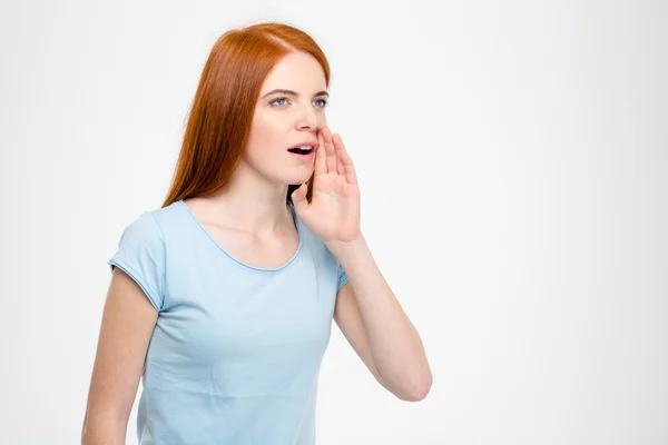 Beautiful redhead woman screaming with hand near her mouth — Stockfoto