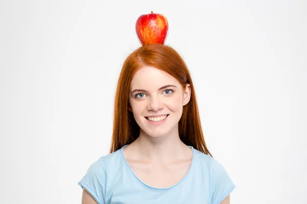 Mulher ruiva sorridente de pé com maçã na cabeça — Fotografia de Stock