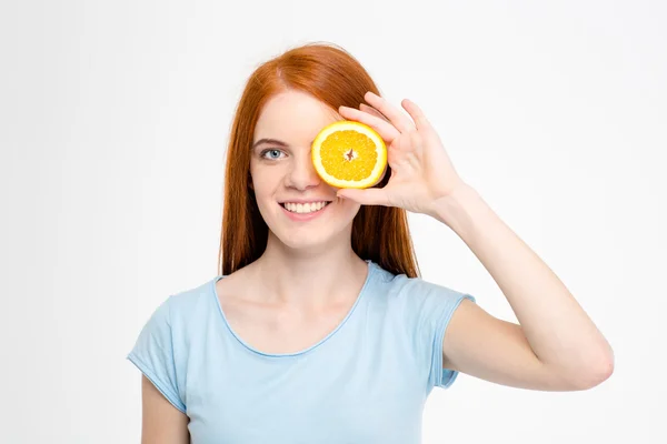 Donna sorridente che copre l'occhio con arancione — Foto Stock
