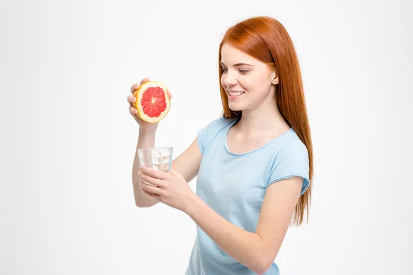 Happy smiling lady pressing grapefruit juice in glass — Stock Fotó