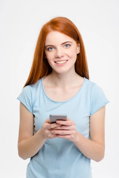 Smiling redhead woman using smartphone — Stock Photo, Image