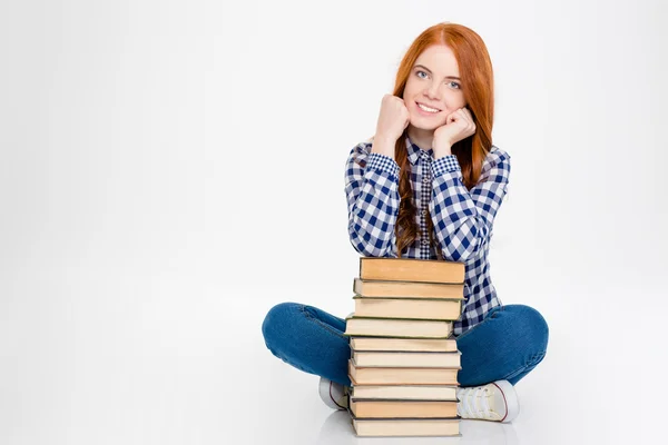 Belle jeune fille rousse heureuse assise et posant avec des livres — Photo