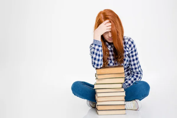 Senhora sonolenta se apoiando na pilha de livros e tendo dor de cabeça — Fotografia de Stock