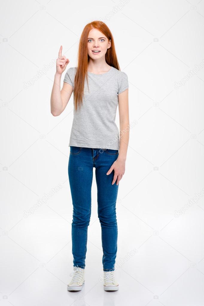 Happy amazed young female standing and pointing up