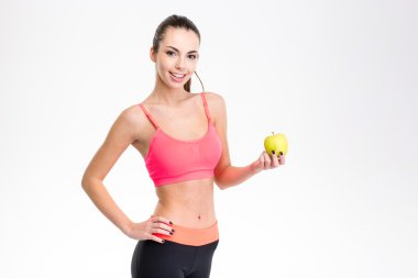 Beautiful happy fitness girl holding an apple