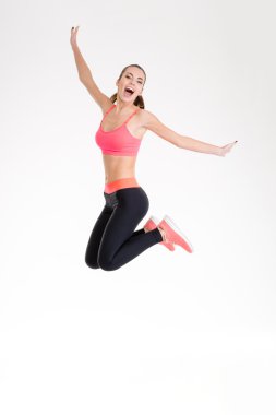 Happy joyful young fitness woman jumping 