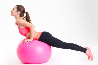 Çekici genç sporcumuz pembe fitball üzerinde germe egzersizleri yapıyor odaklı 