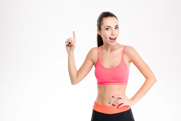 Bonita esportista de traje apontando para cima e ter uma ideia — Fotografia de Stock