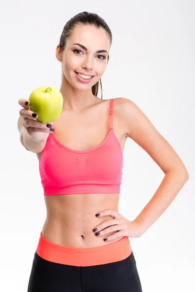 Pretty positive young sportswoman giving an apple — ストック写真