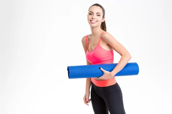Attractive cheerful young sportswoman holding yoga mat — Stock Photo, Image