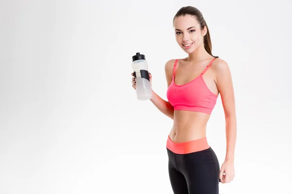 Ziemlich süße fröhliche Fitness-Mädchen hält eine Flasche Wasser — Stockfoto