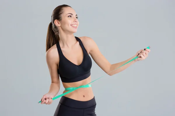 Portrait of excited happy young fitness woman with measuring tape — 图库照片