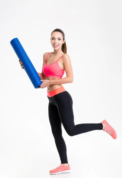 Pretty positive fitness woman running on training with  yoga mat — Stockfoto