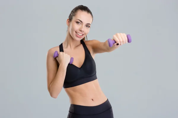Positive pretty fitness girl exercising with dumbbells — Stockfoto