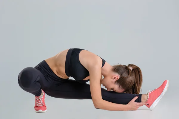 Concentrated beautiful fitness girl doing strething exercises — Stock Photo, Image