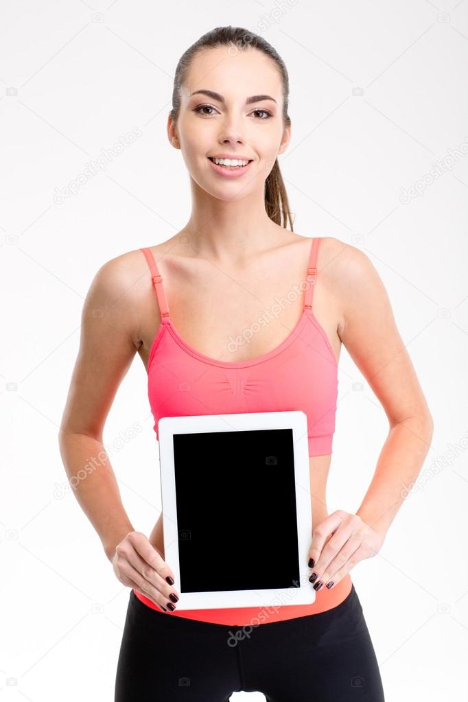 Pretty positive fitness girl holding blank tablet computer screen 