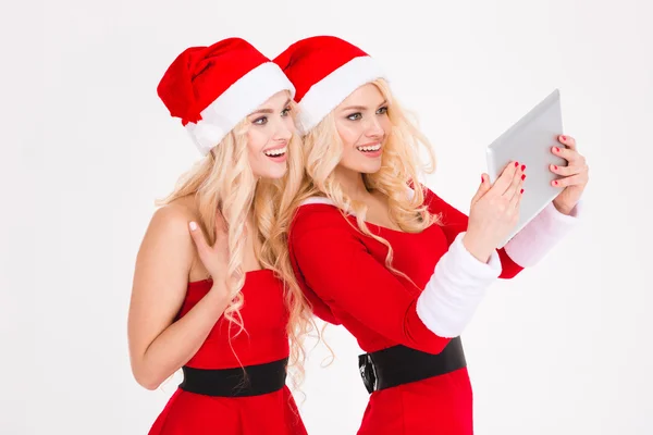 Feliz hermanas atractivas gemelas haciendo selfie usando tableta — Foto de Stock