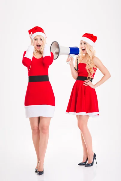 Atractivas hermanas gemelas en trajes de Santa Claus hablando en altavoz — Foto de Stock