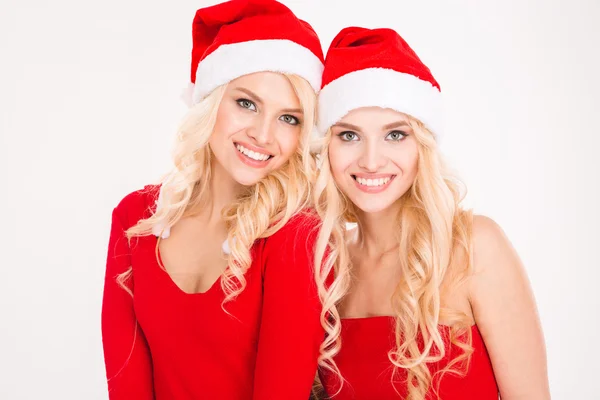 Beautiful cheerful sisters twins in santa claus clothes and hats — Stok fotoğraf