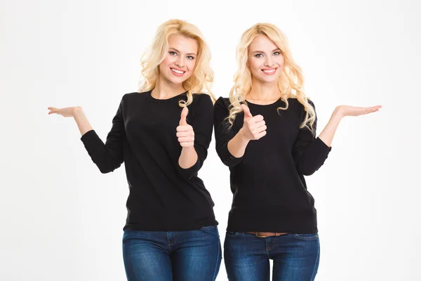 Sisters twins showing thumbs up — Stock fotografie