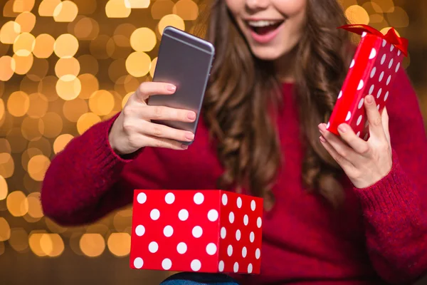 Happy woman in santa hat opened present and got smartphone — Stockfoto