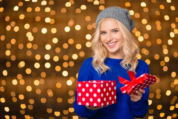 Happy woman opening gift box over holdays lights — Zdjęcie stockowe