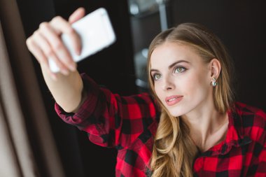 Güzel attracrive genç kadın alma selfie ile hareket eden telefon