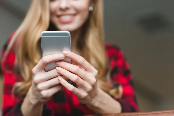 Close up of smaptphone used by beautiful smiling young woman — Stock Photo, Image