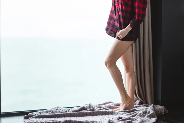Krásné štíhlé nohy mladé ženy v kostkované košili — Stock fotografie