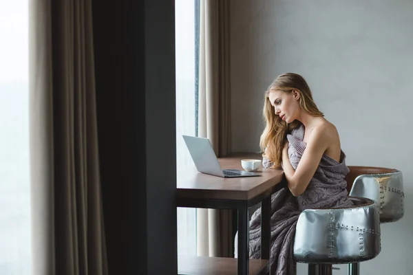 Aantrekkelijke ontspannen jonge vrouw met behulp van laptop en drinken koffie — Stockfoto