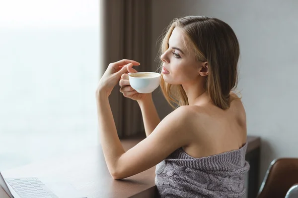 Atractiva mujer sensual sentada a la mesa y tomando café —  Fotos de Stock
