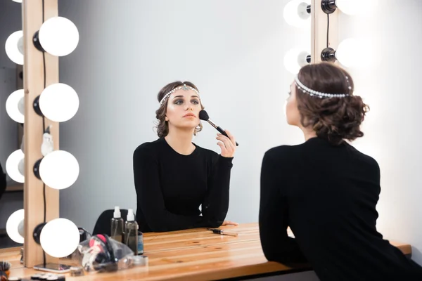 Mujer aplicando cosmética con pincel — Foto de Stock