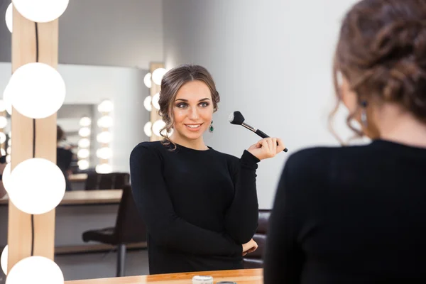 Happy woman applying cosmetic with brush — Stock Photo, Image