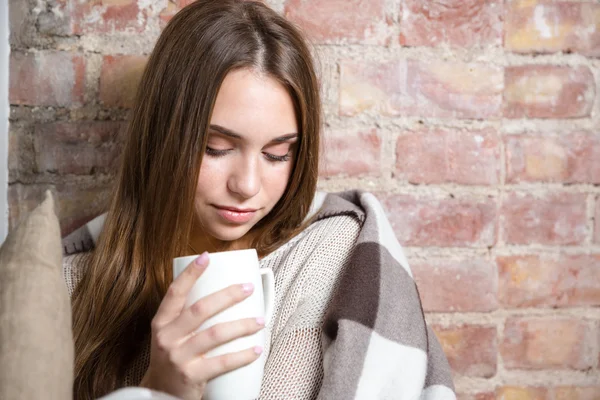 Hermosa mujer en cálida taza de celebración de cuadros con té caliente —  Fotos de Stock