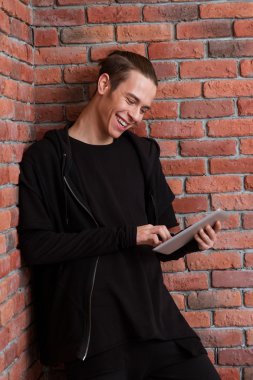 Tablet bilgisayar kullanan gülümseyen casual adam