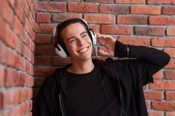 Glimlachend casual man luisteren muziek in hoofdtelefoon — Stockfoto
