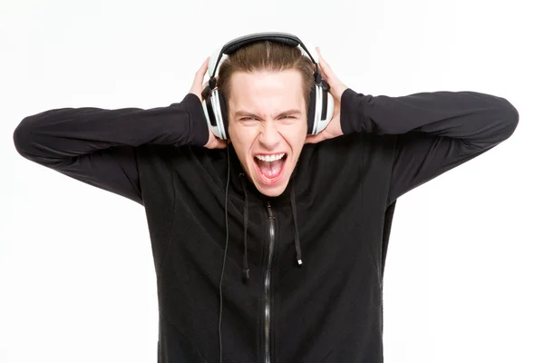 Mand lytter musik i hovedtelefoner og skrigende - Stock-foto