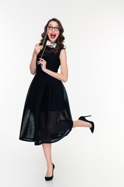Charming girl posing with fake glasses and bow tie props 