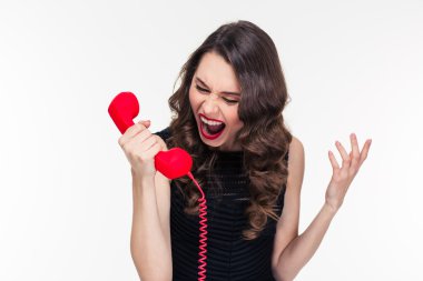 Crazy raged retro styled female shouting in red telephone receiver 