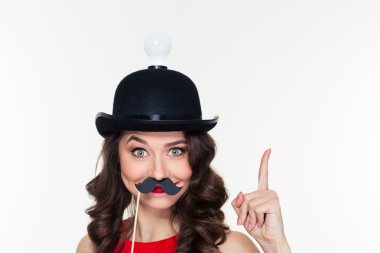 Girl in hat with light bulb using fake moustache props