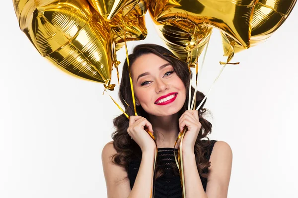 Cheerful happy beautiful woman in retro style holding golden balloons — Stock Photo, Image