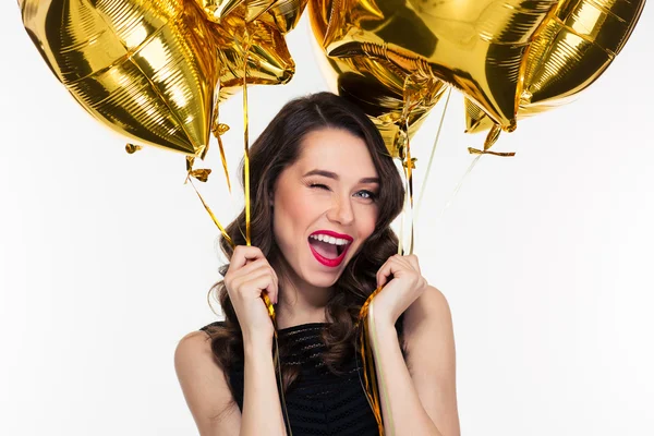 Portrait of flirty attractive winking curly woman with golden balloons — Stockfoto